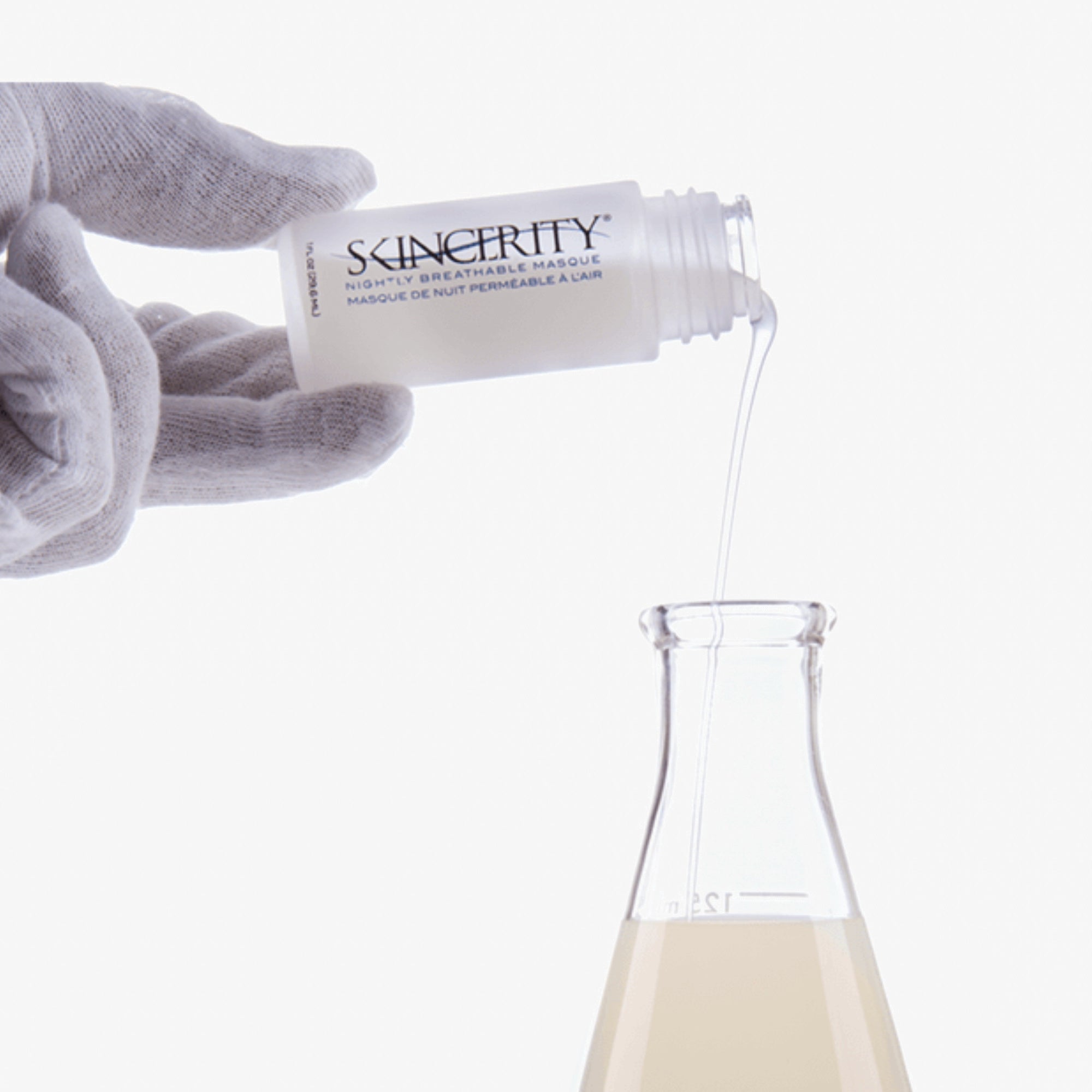 A hand with a glove pouring Skincerity Nightly Breathable Masque into a flask to emphasize its scientific development