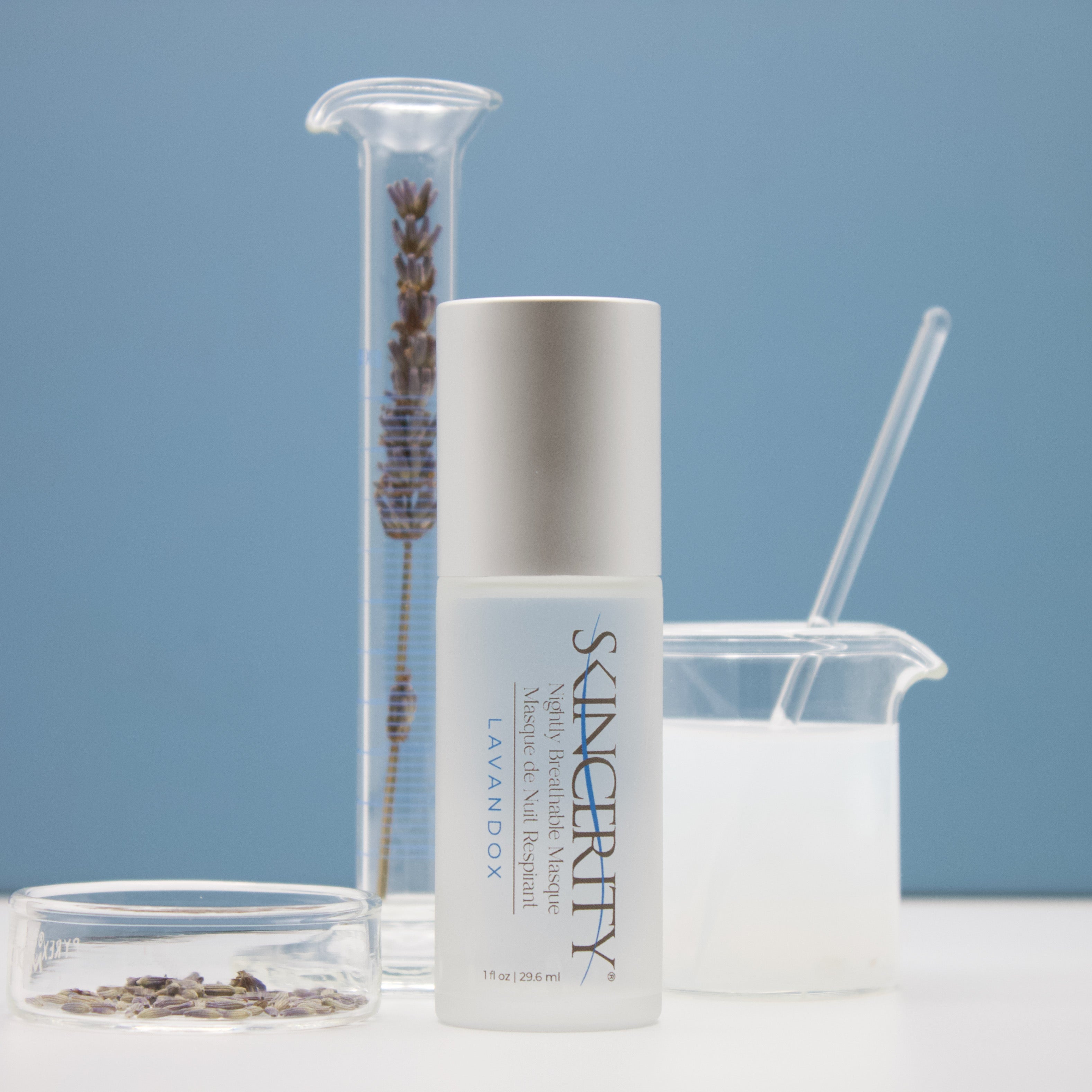 Skincerity Lavandox bottle displayed with lavender sprigs in a graduated cylinder and petals in a glass dish, highlighting the cutting-edge Lavandox technology, a lavender-derived ingredient